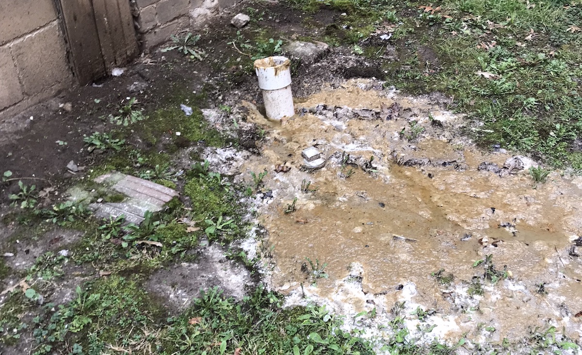 Photo of raw sewage spilling into a yard